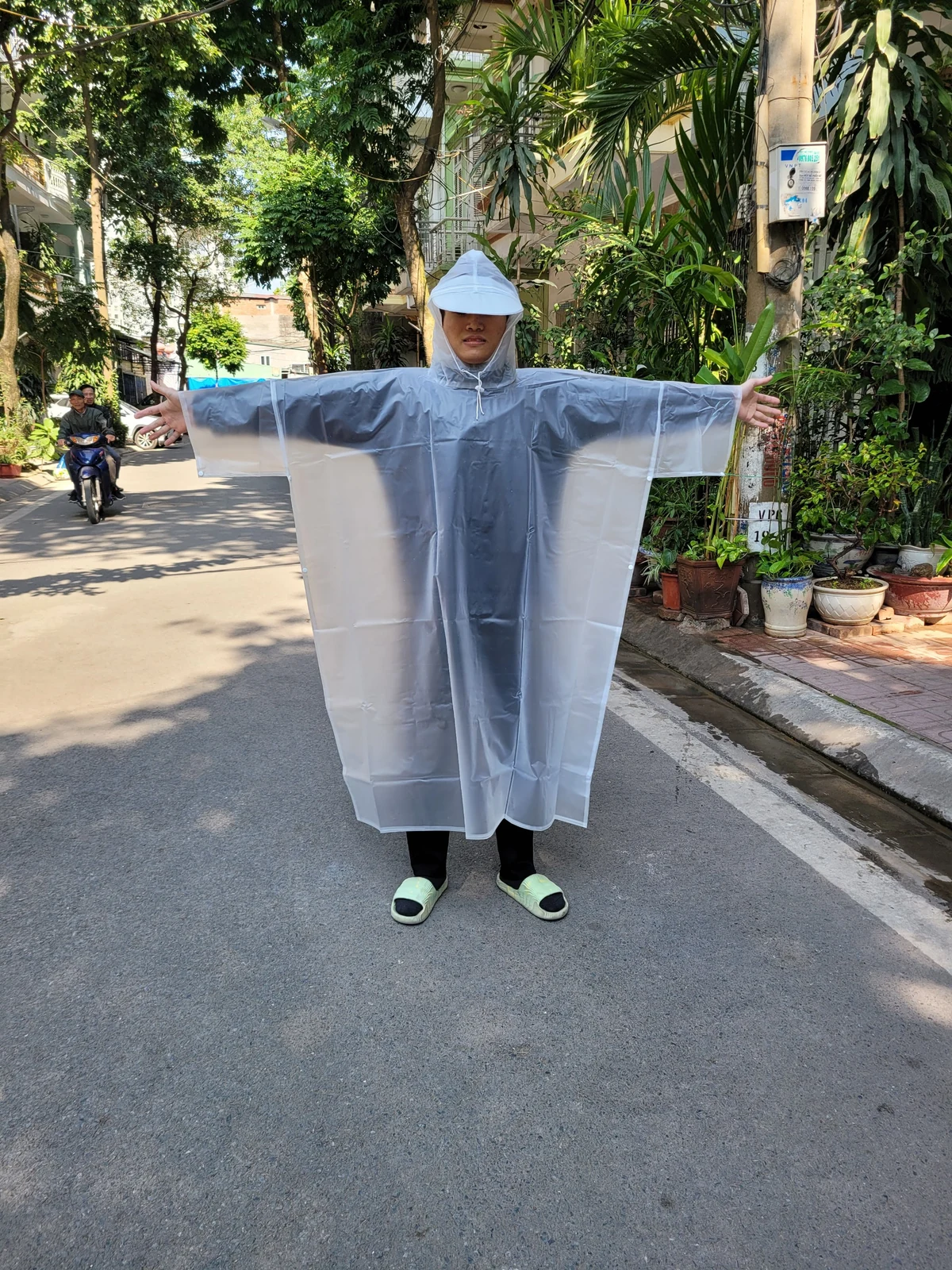 Góc mặc phía trước của áo mưa trắng trong, mũ liền và cạnh bấm