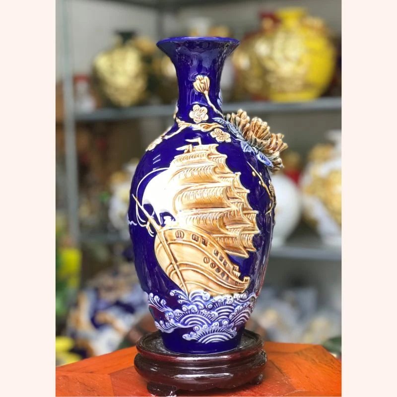 Bản men xanh lam với hình thuyền nổi và đế màu nâu.