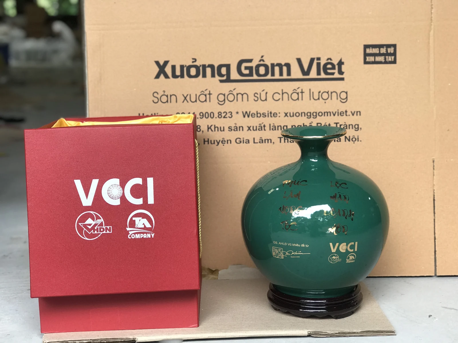 Mặt sau bình xanh đậm với lời chúc và nhận diện VCCI trong ảnh nguồn