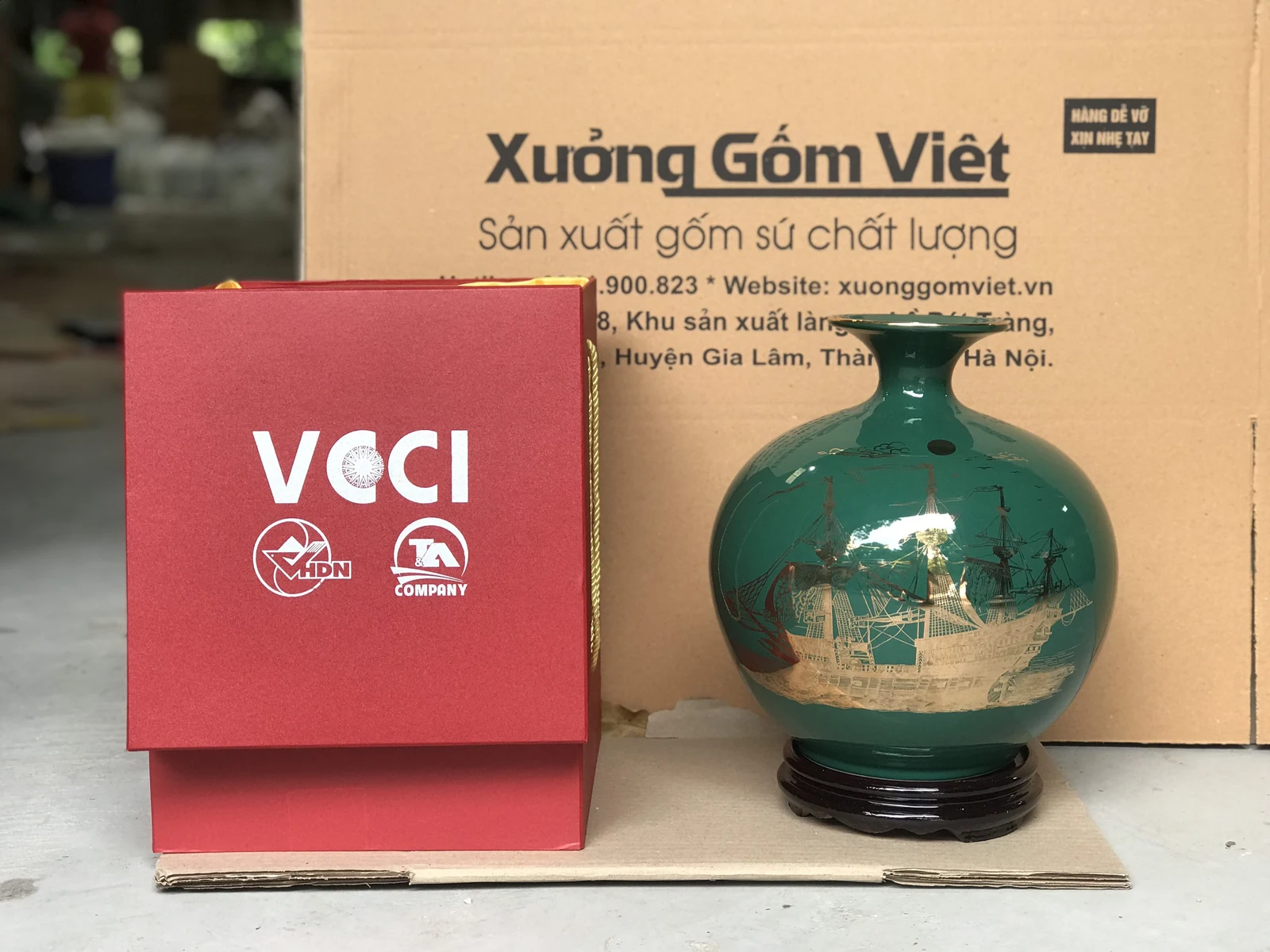 Ảnh chụp mặt thuyền buồm của bình xanh đậm cùng đế và hộp đỏ tham khảo