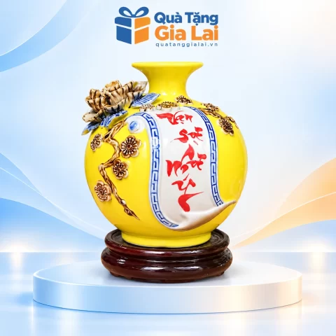 Bình Vạn sự như ý H18 men vàng với cuốn thư chữ đỏ và đế gỗ trên nền Quà Tặng Gia Lai