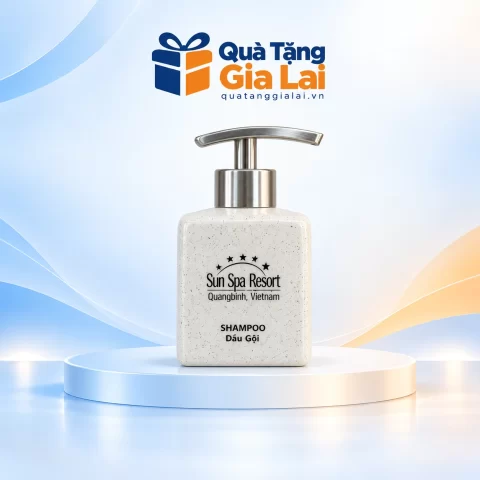 Bình dầu gội vuông nhỏ men lấm tấm, vòi inox bạc và chữ nhận diện trên nền Quà Tặng Gia Lai