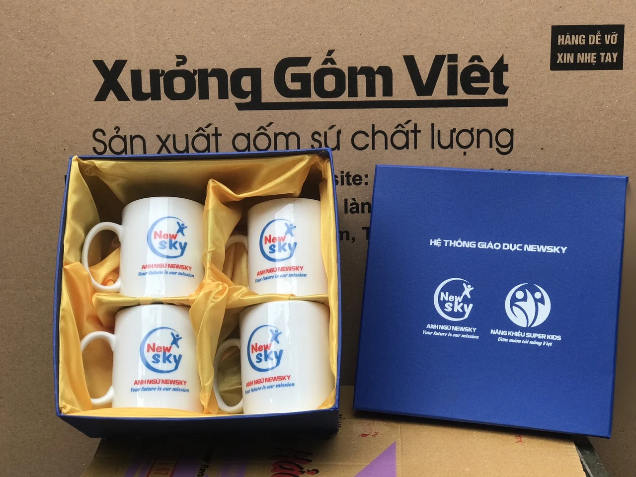 Bộ bốn cốc in logo Newsky trong hộp xanh lót màu vàng