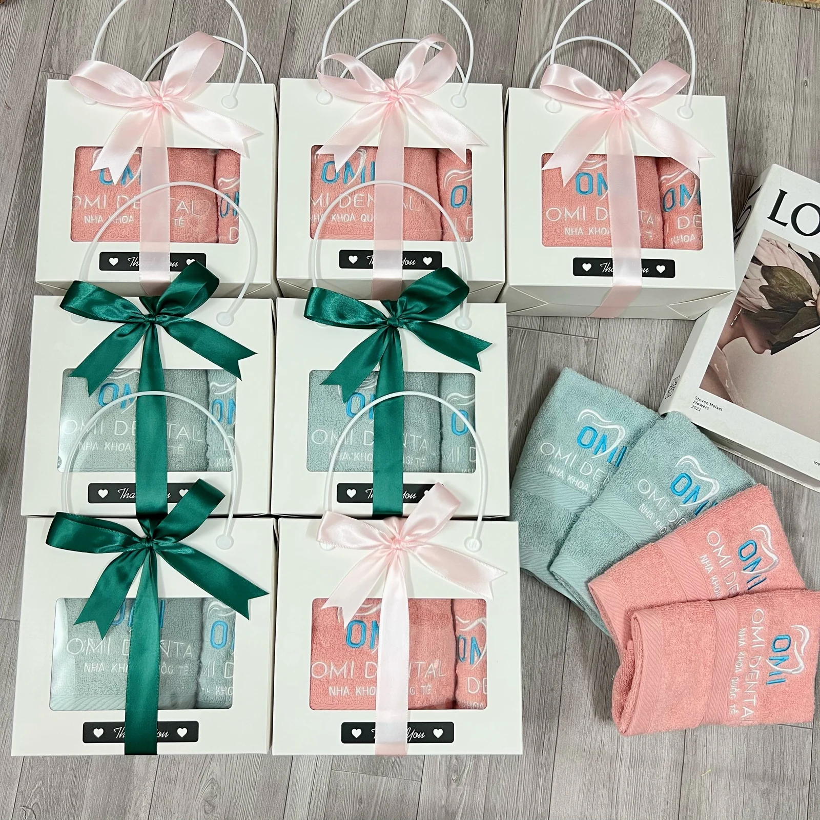 Các bộ khăn hồng và xanh trong hộp dây xách