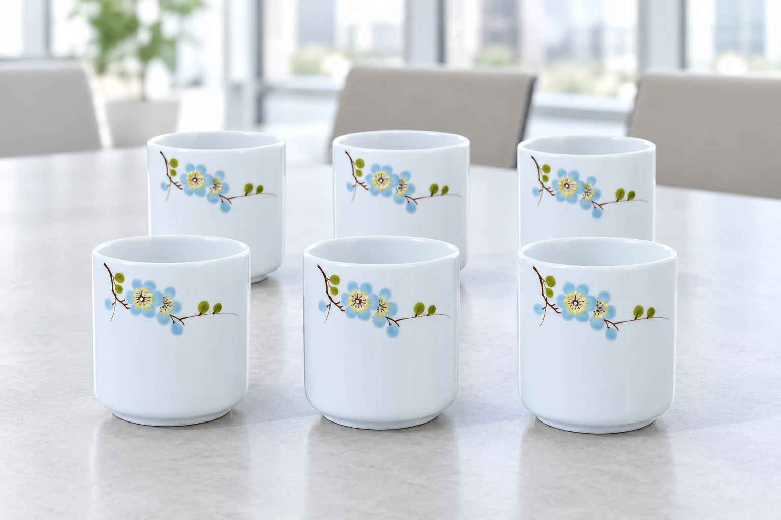 Sáu cốc men trắng hoa xanh bày riêng trên bàn trong văn phòng