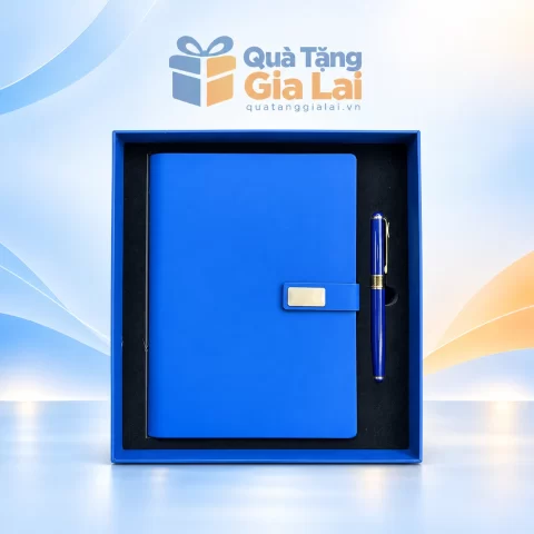 Bộ sổ bút xanh có đai cài kim loại trong hộp trên nền Quà Tặng Gia Lai