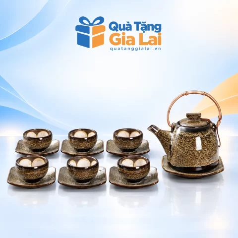 Bộ trà Gấm Chuông 2 quai đồng với sáu chén và bảy đĩa trên nền Quà Tặng Gia Lai