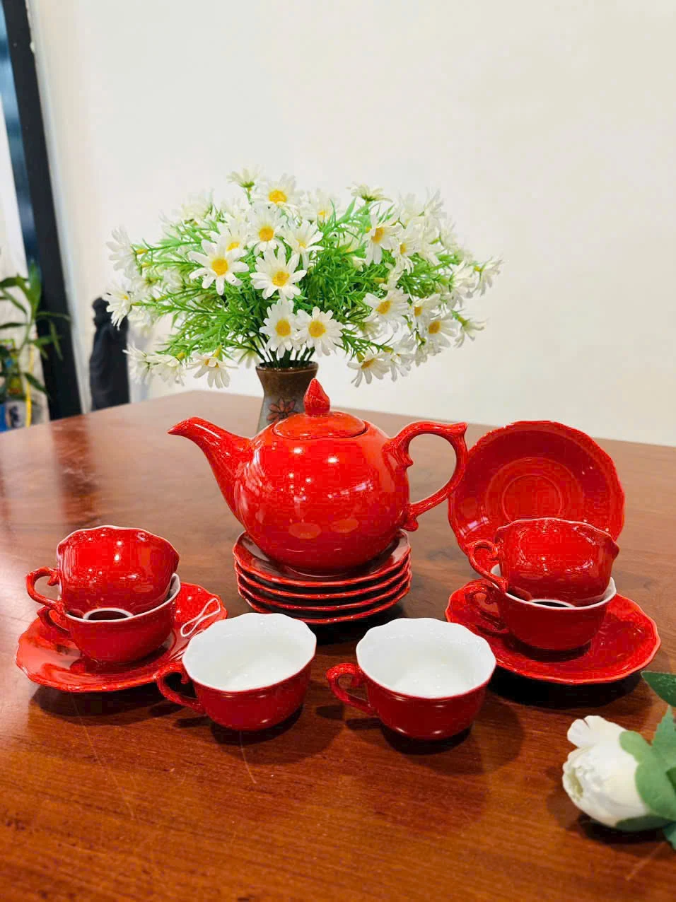 Bộ trà mẫu đơn đỏ bày trên bàn cùng các chén và đĩa