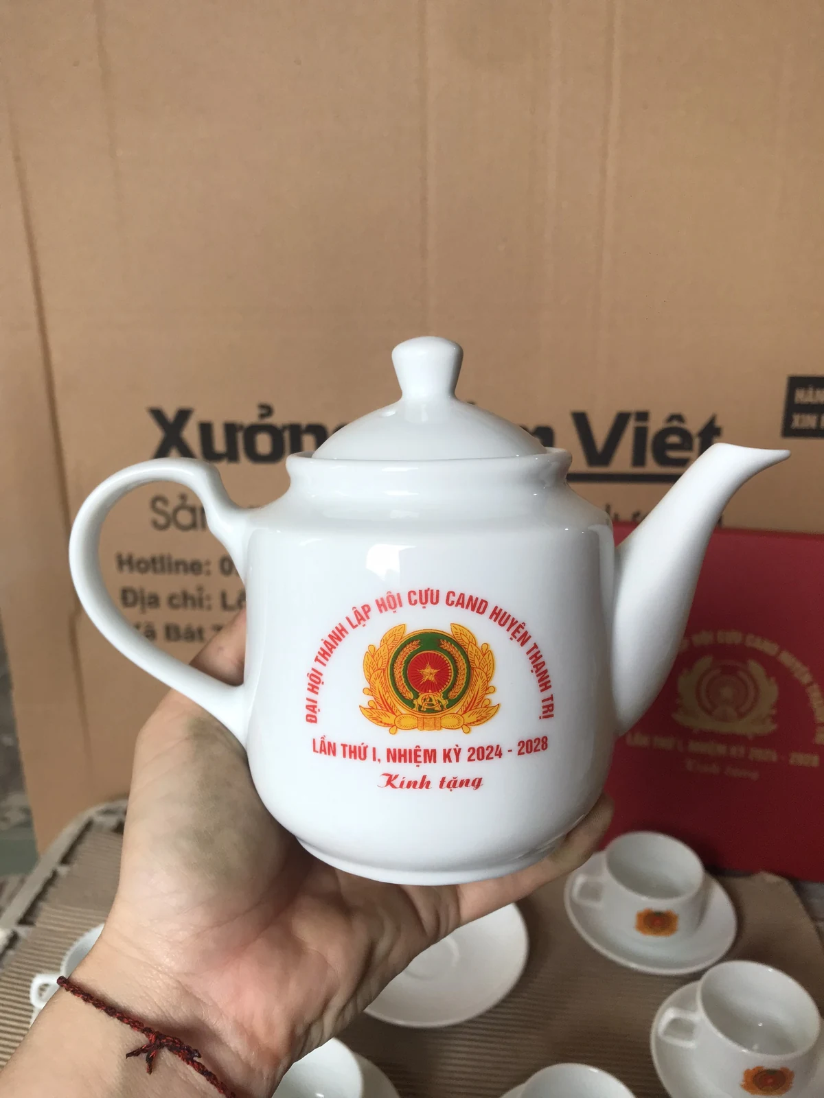 Chi tiết ấm với biểu trưng và chữ kỷ niệm