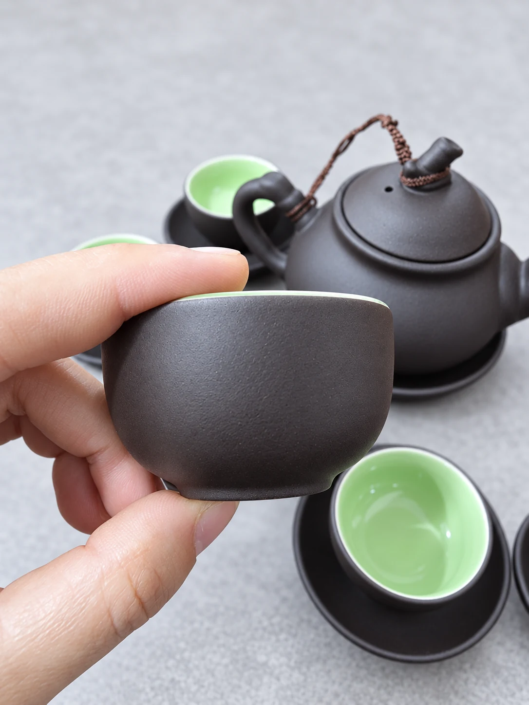Chi tiết chén nâu sẫm, miệng tròn không quai và lòng xanh nhạt