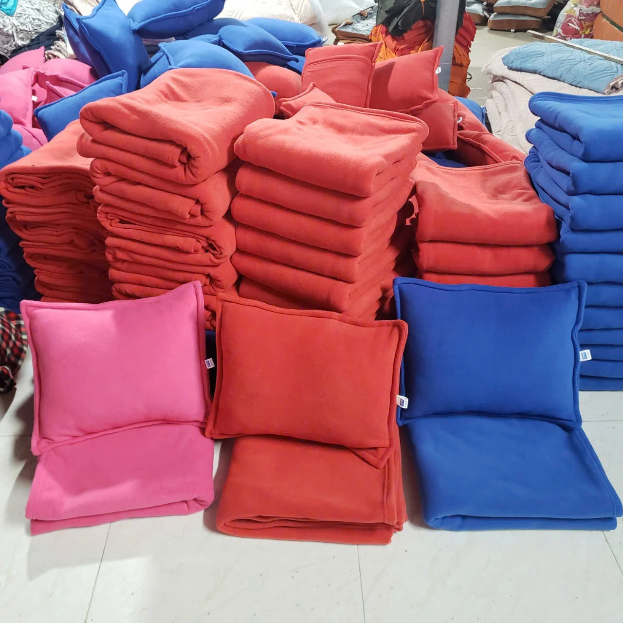 Gối vuông và mền màu đỏ hồng xanh trong ảnh nguồn