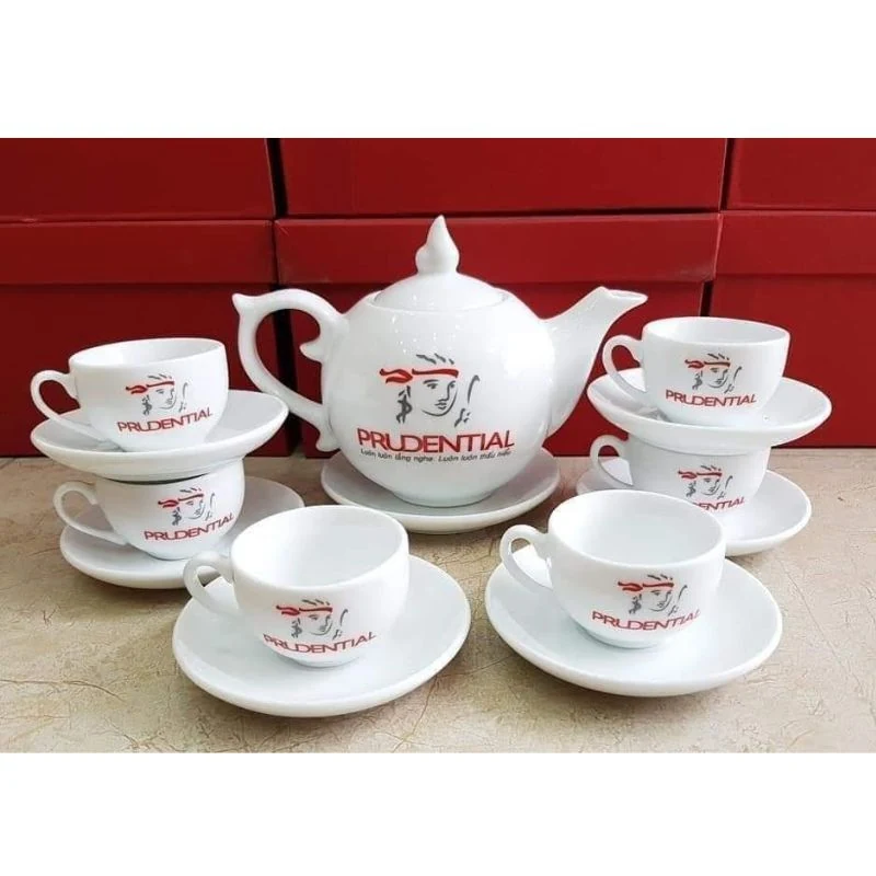 Bố cục biểu trưng và tên thương hiệu màu đỏ trên bộ trà.