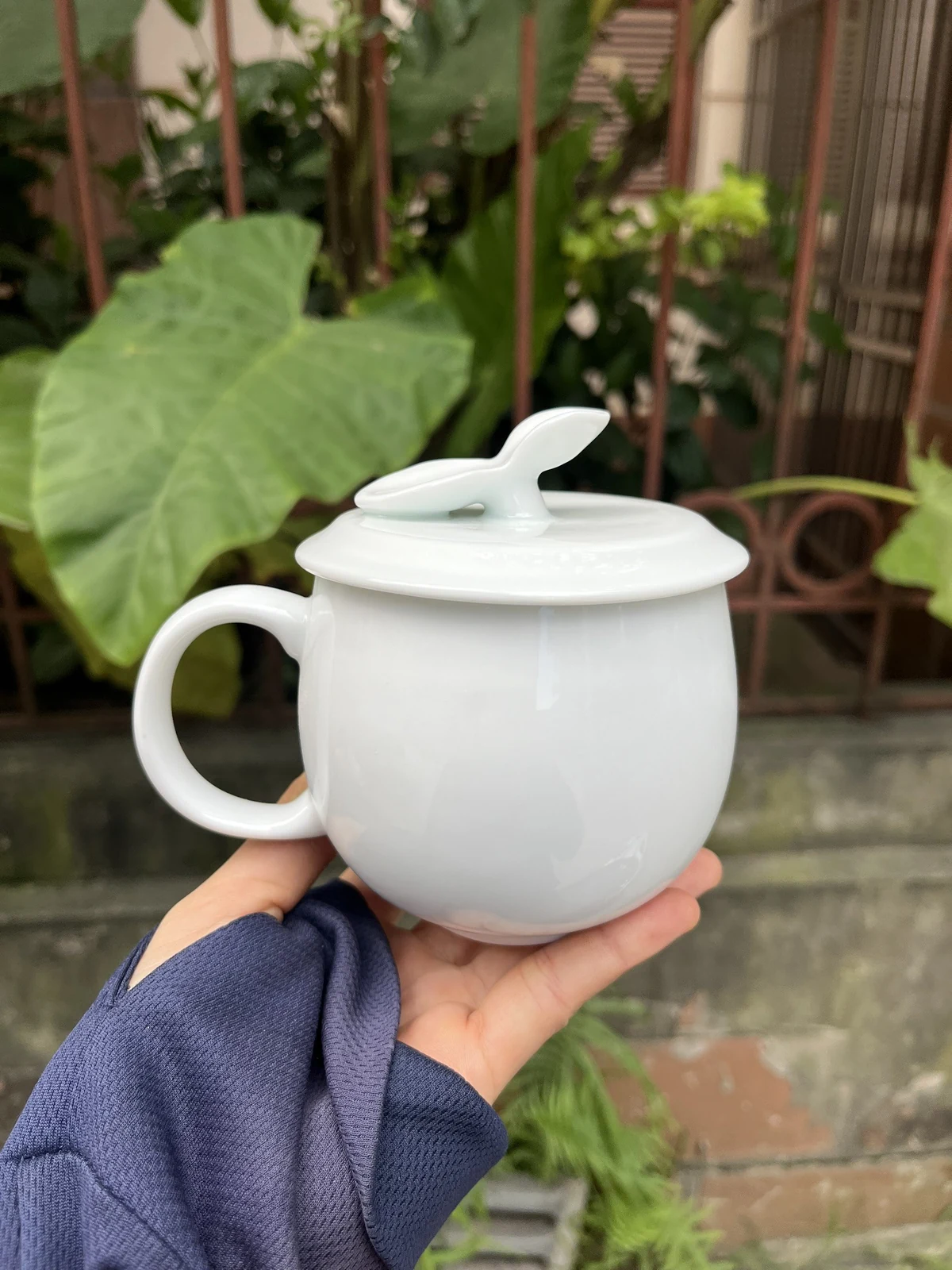 Cốc nắp táo trắng được cầm trên tay trong ảnh thực tế