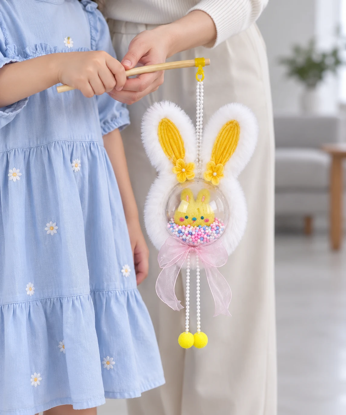 Cầm đèn lồng thỏ tai vàng bằng cần gỗ với người lớn hỗ trợ