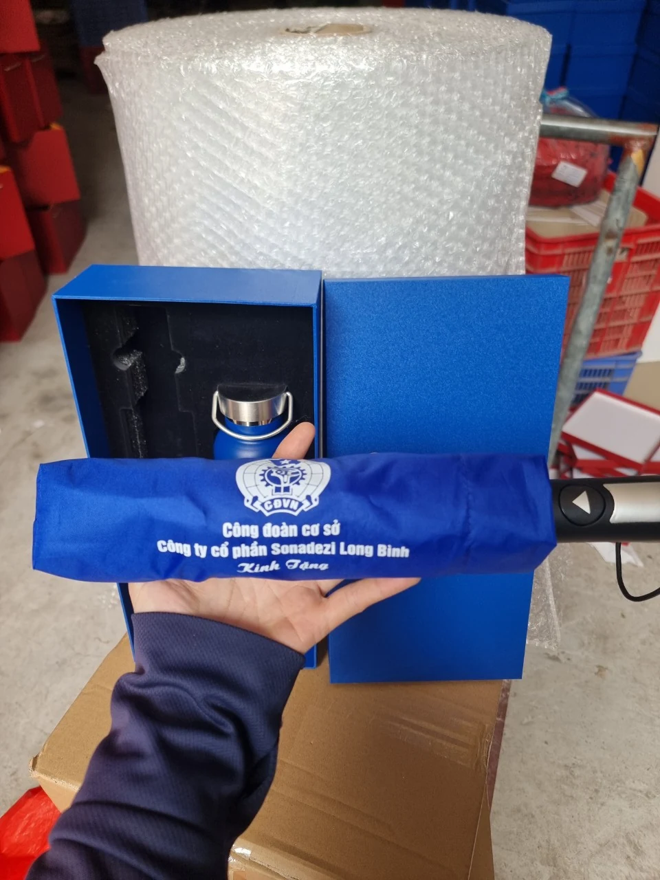 Dù gấp gọn trong bao xanh, tay cầm đen phối màu bạc