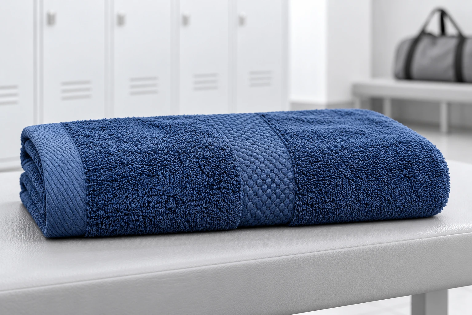 Một khăn cotton xanh navy gấp trên ghế khu thay đồ