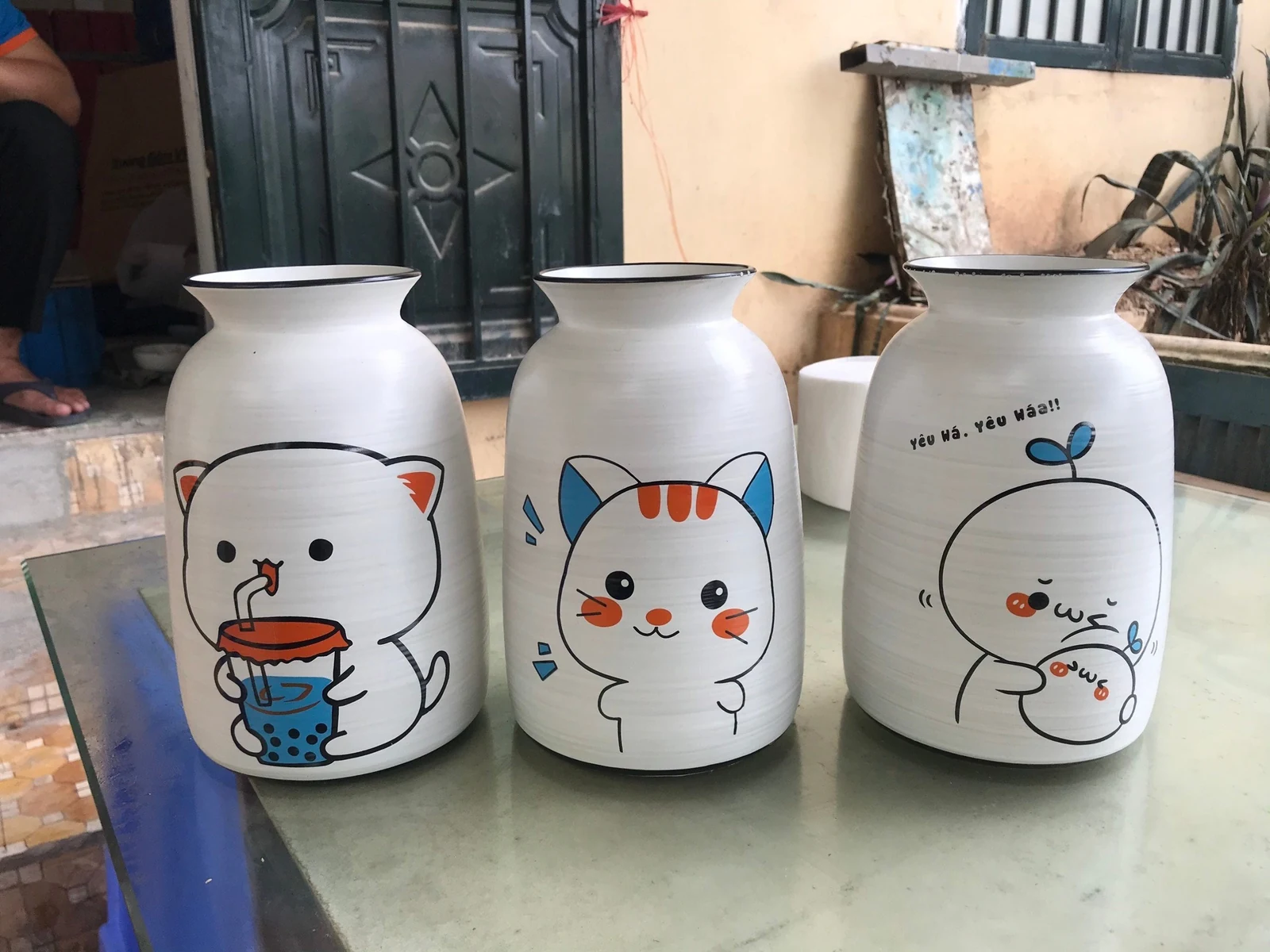 Ba hình nhân vật trên lọ men xước, mèo tai xanh ở giữa