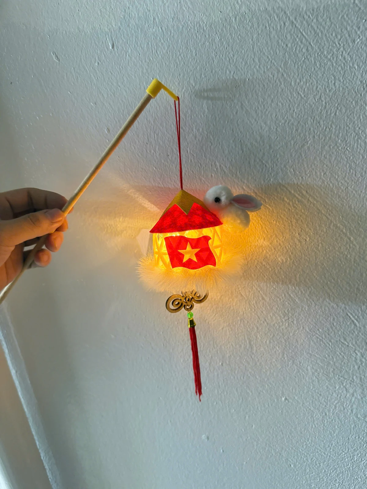 Cầm mẫu thỏ bám nón bằng cần gỗ khi bật sáng