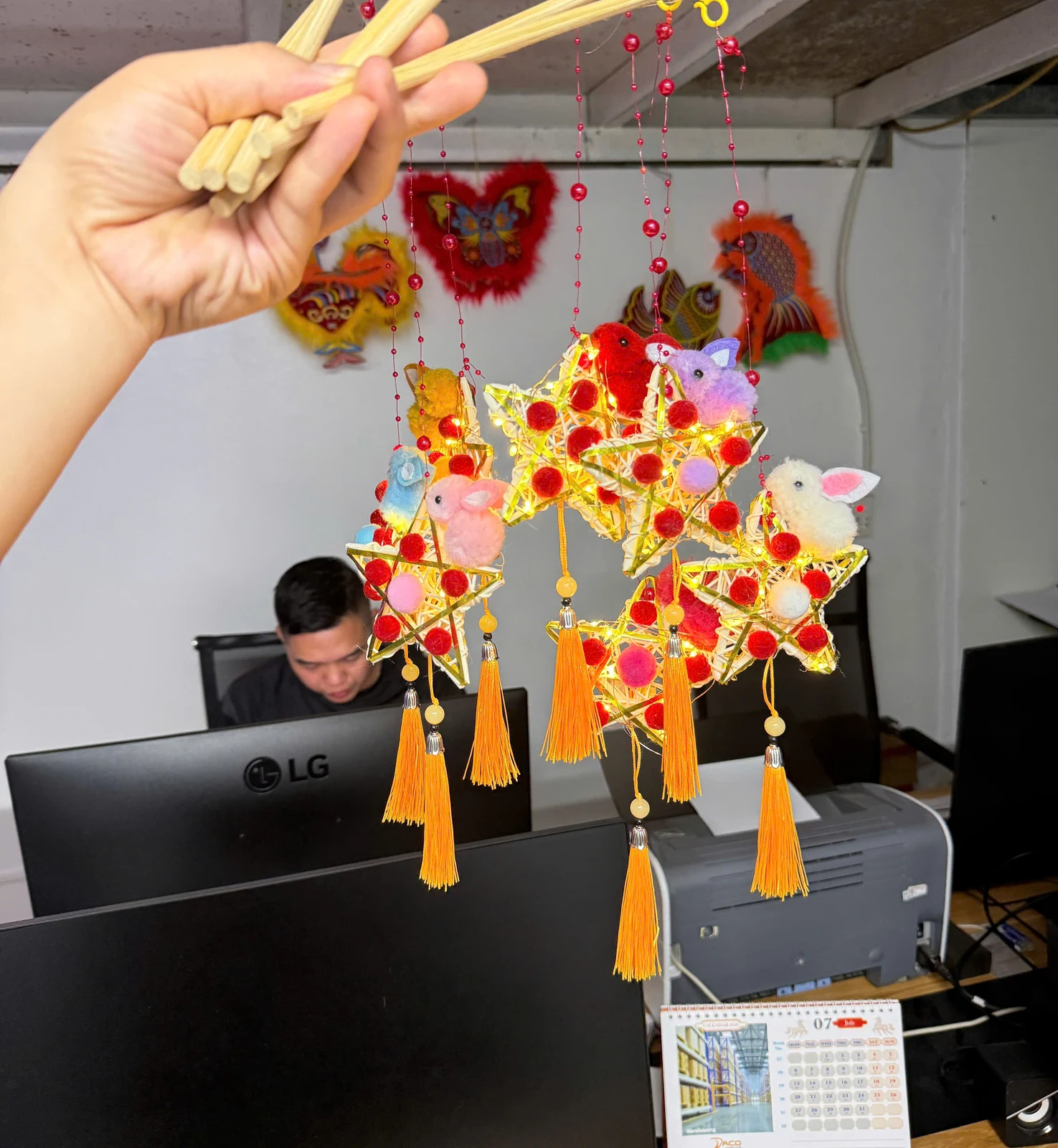 Các mẫu đèn thỏ ngôi sao đang sáng, treo theo cần gỗ và dây hạt đỏ