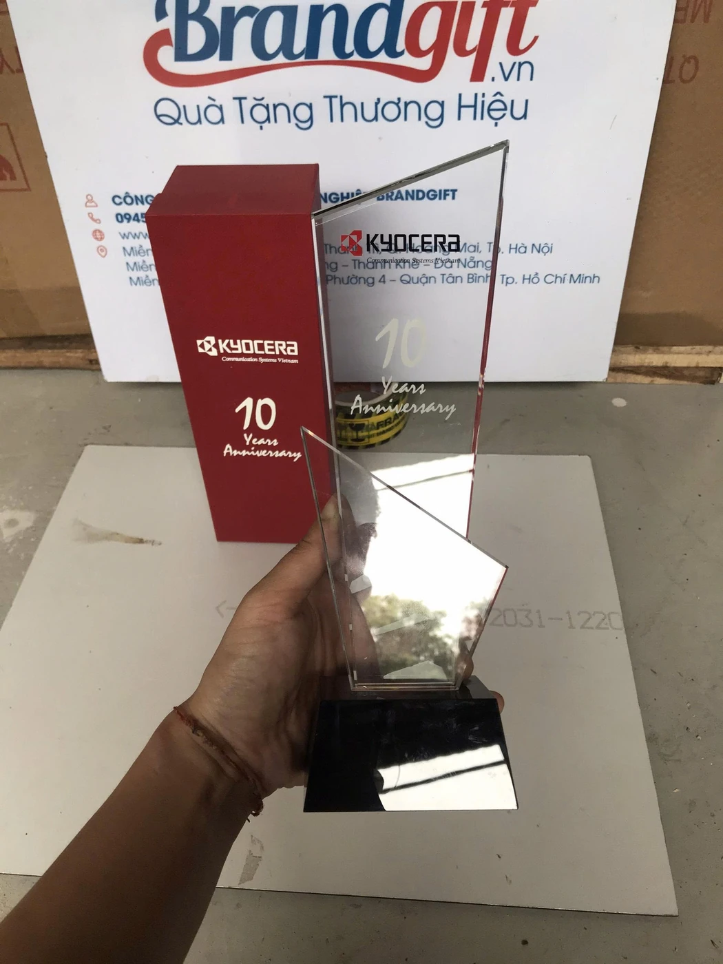 Ảnh thật kỷ niệm chương KYOCERA có nhiều dòng chữ trên mặt trong suốt