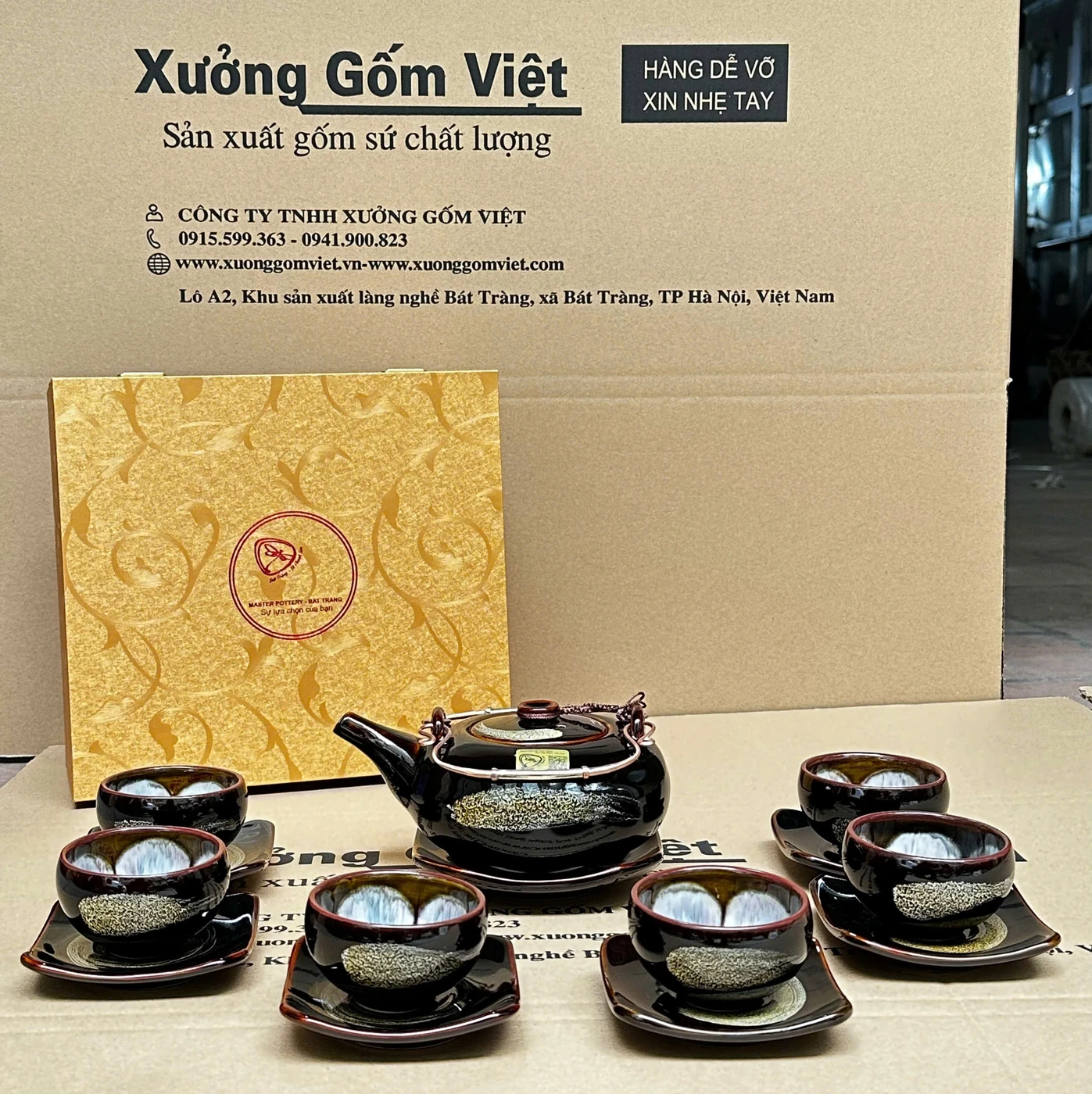 Ảnh thật một bộ trà màu đen có ấm, sáu chén và các đĩa bày cùng hộp phía sau