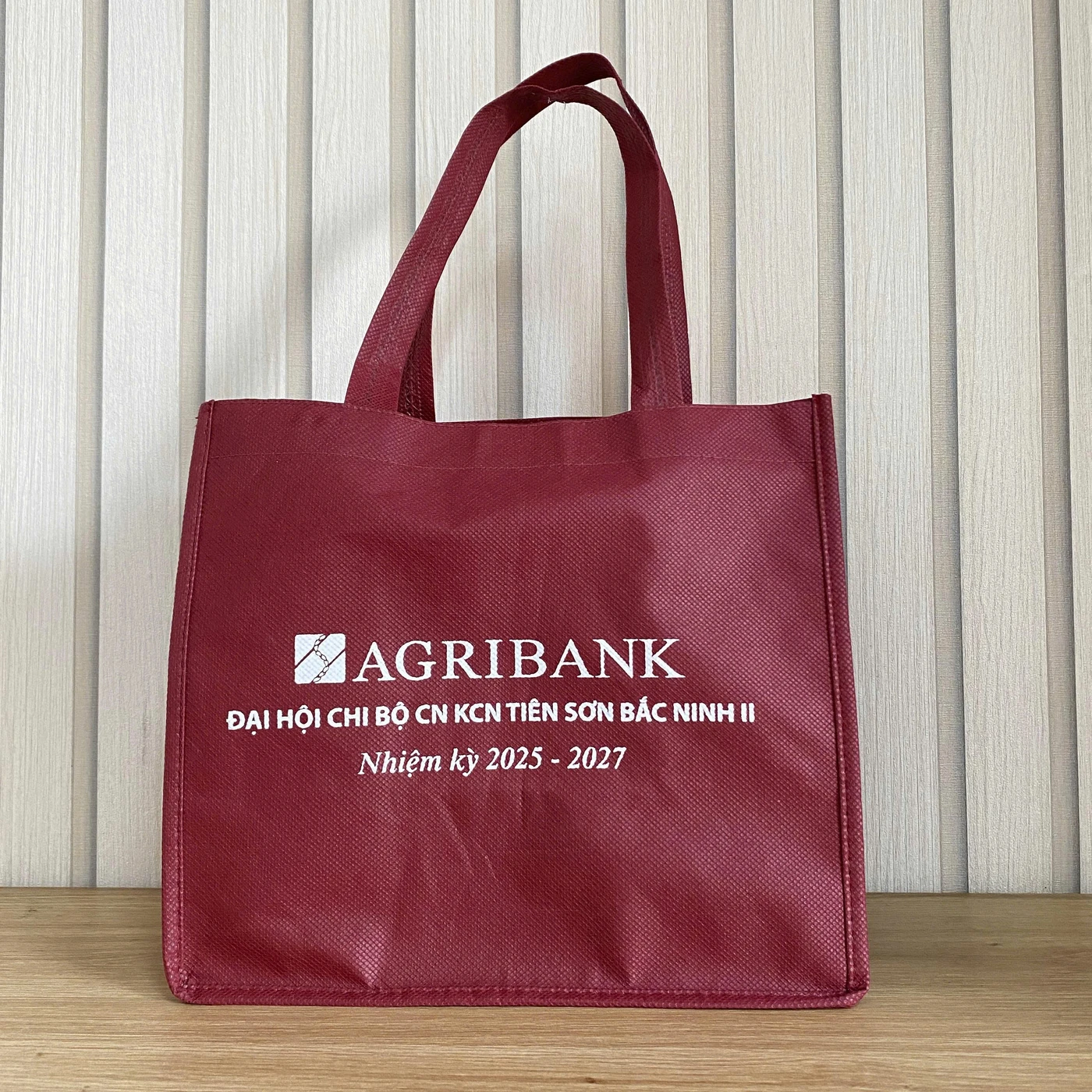 Ảnh thật túi đỏ AGRIBANK có quai và nội dung chương trình in trên mặt túi