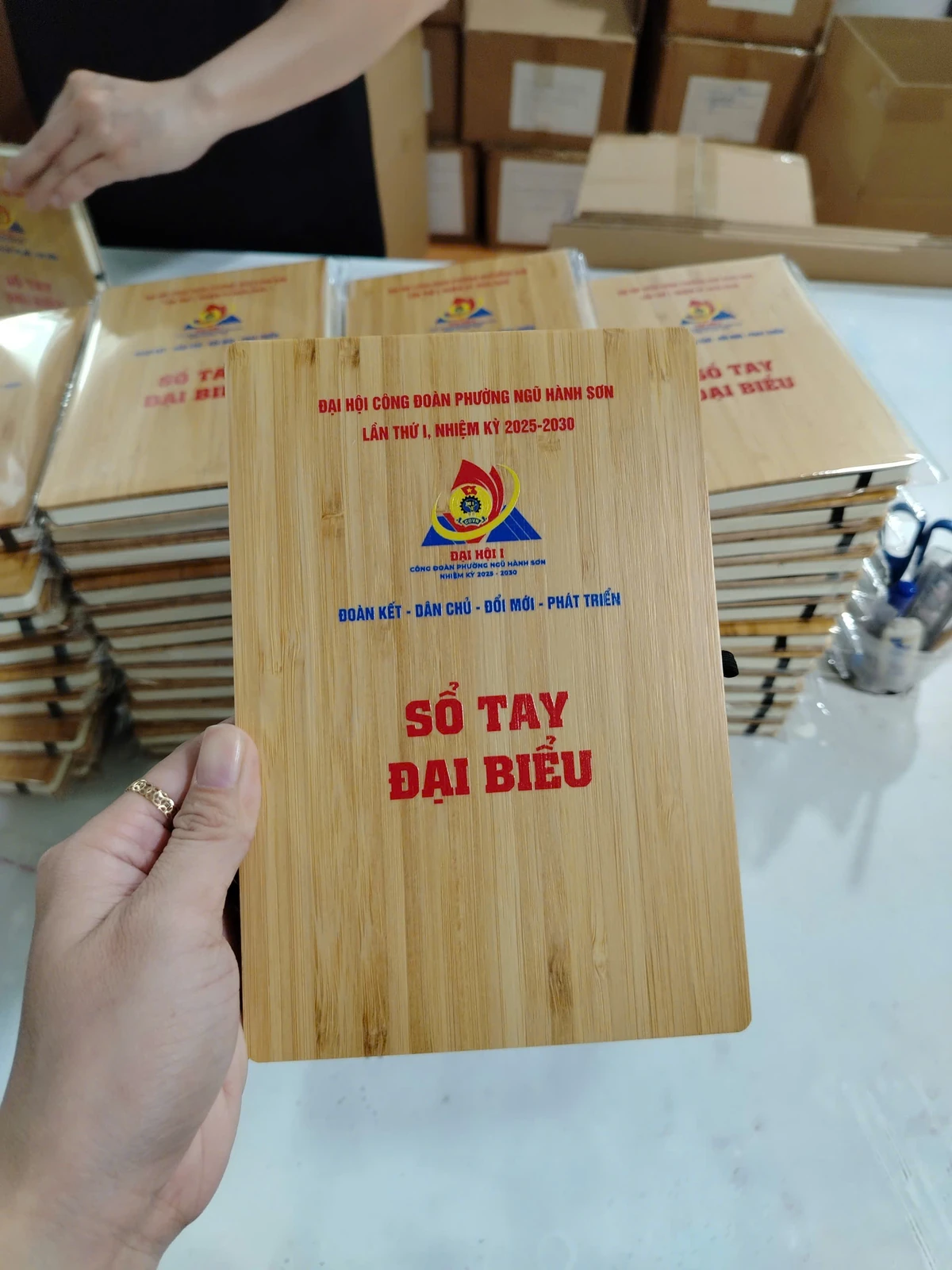 Góc cầm thật sổ bìa tre với một bản in nội dung riêng