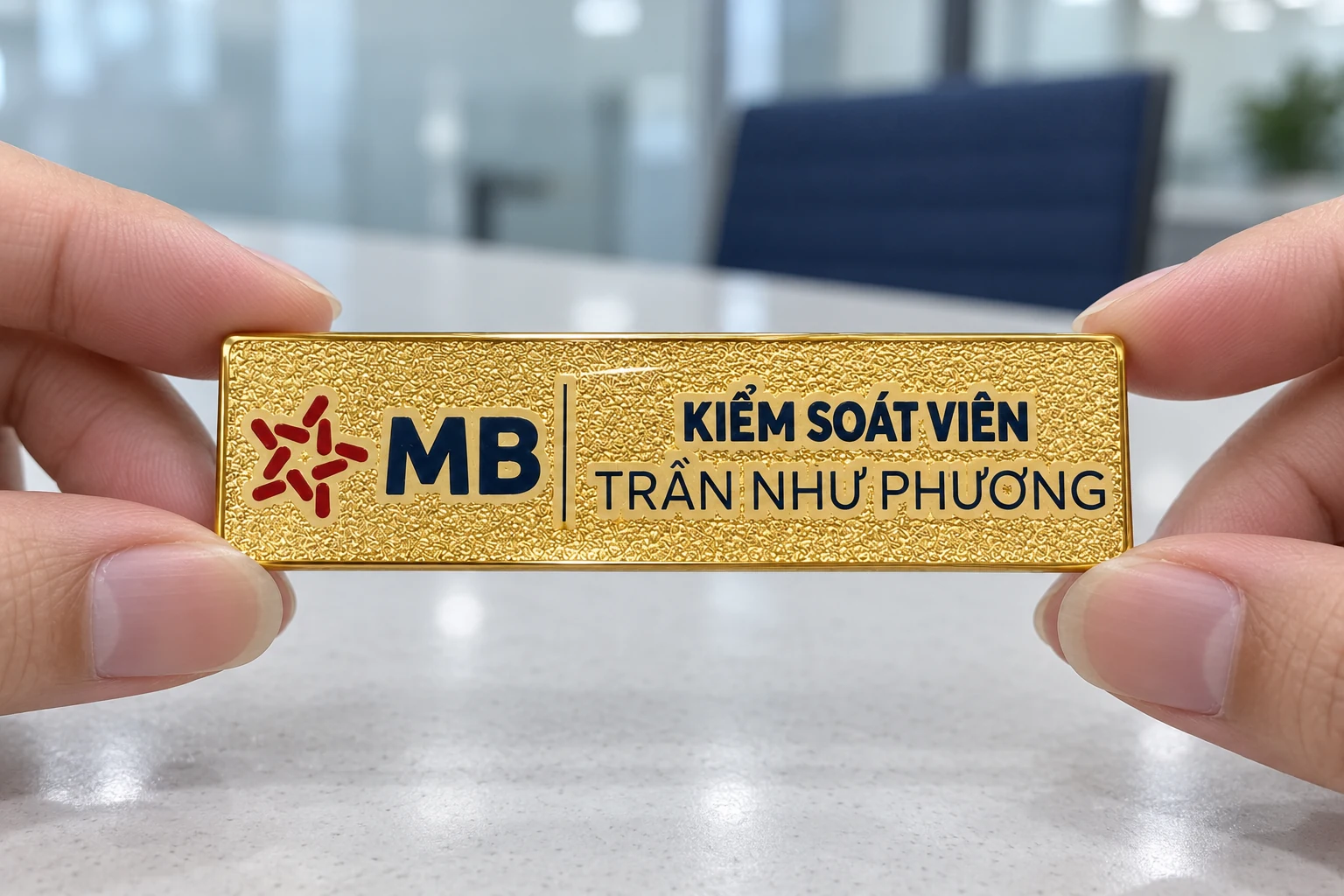 Thẻ tên vàng sần được xem ở bàn làm việc sáng màu