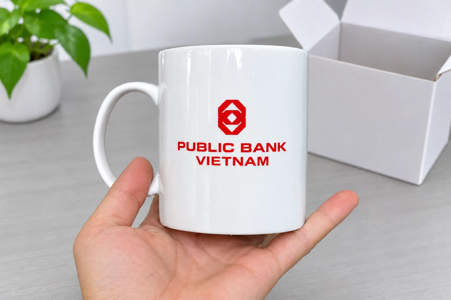 Tay đỡ cốc trắng có logo Public Bank Việt Nam để xem mặt in